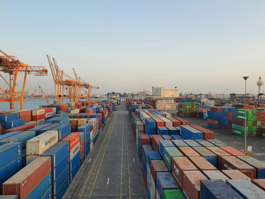 A bustling port scene with colorful cargo containers at sunrise. Ideal for logistics concepts.